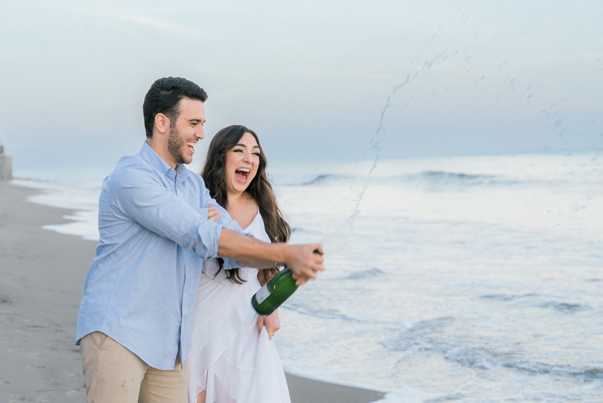 champagne pop by the beach during an engagement session in santa barbara, ca