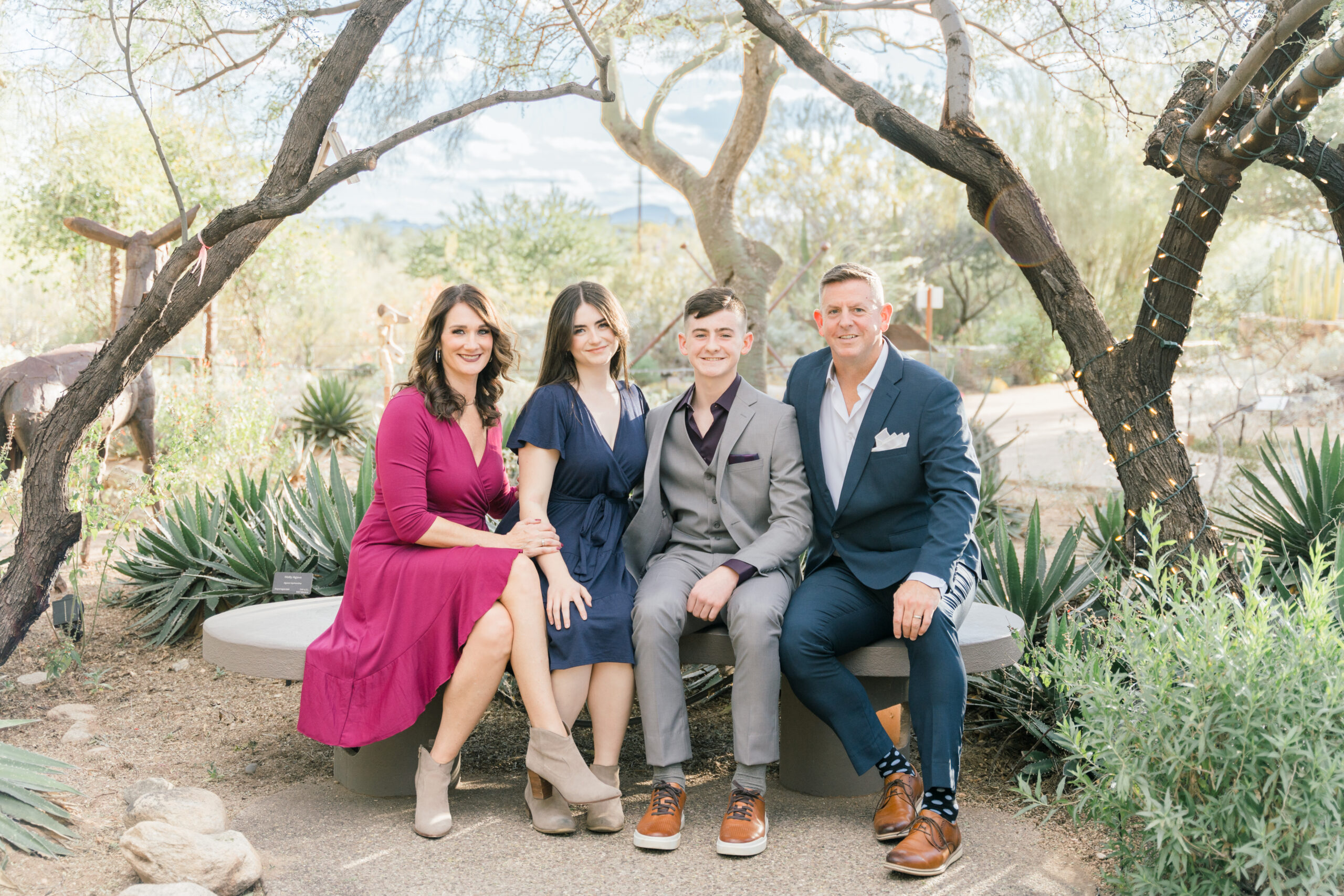 Family Photography Session at Tohono Chul Botanical Gardens. Parents and Teens pose together on a bench. Ruby Sandoval Photography.